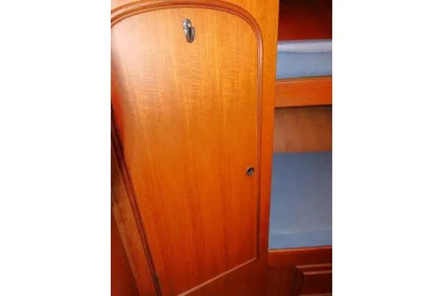 Slide: The Image of Wooden cabin interior with blue bunk beds on a 1983 CHB 45 model boat. - 22