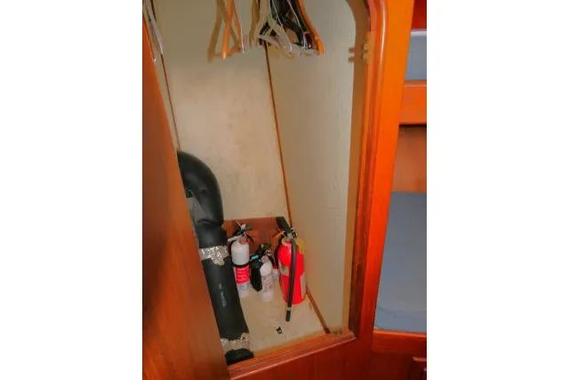 Slide: The Image of Wooden closet interior with fire extinguishers and hangers on a 1983 CHB 45 model. - 23