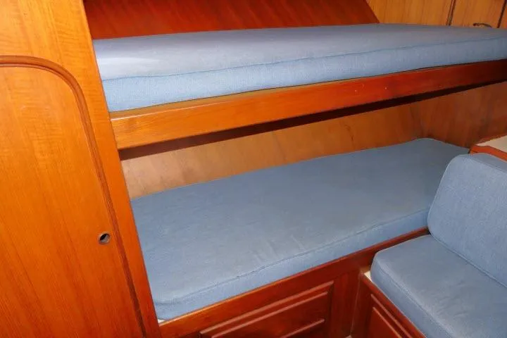 Slide: The Image of Wooden bunk beds with blue cushions in a 1983 CHB 45 model boat. - 24