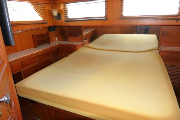 Slide: The Image of 1983 CHB 45 yacht interior with spacious wooden cabin and large bed. - 29