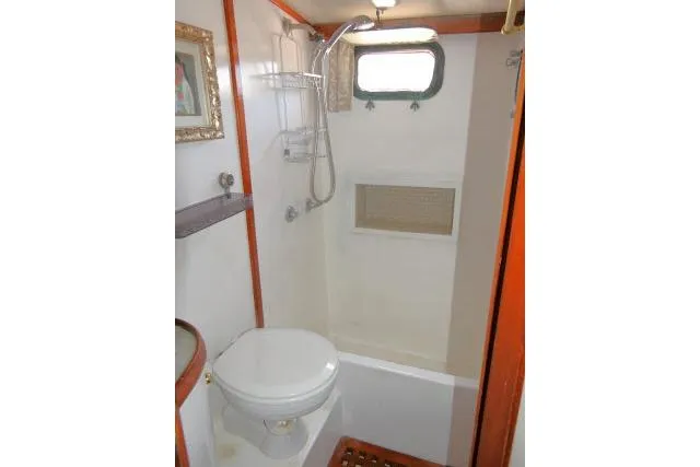 Slide: The Image of 1983 CHB 45 yacht bathroom with shower, toilet, and window. - 36