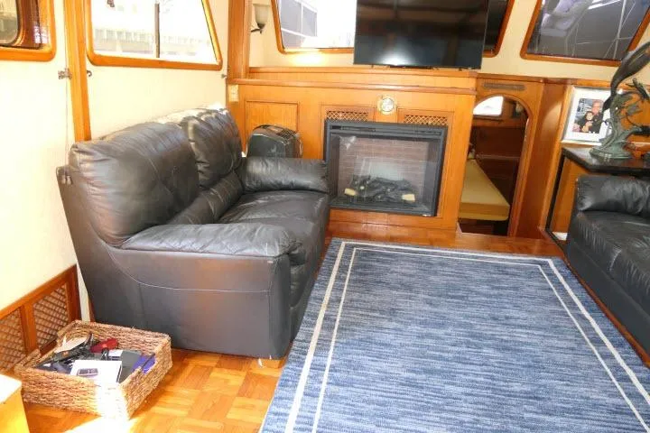 Slide: The Image of Interior of 1983 CHB 45 boat with leather sofa, fireplace, and blue rug. - 4