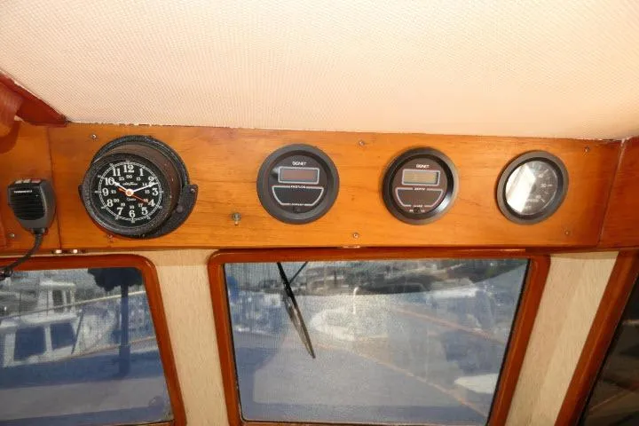 Slide: The Image of Dashboard of a 1983 CHB 45 boat with gauges and a clock. - 41