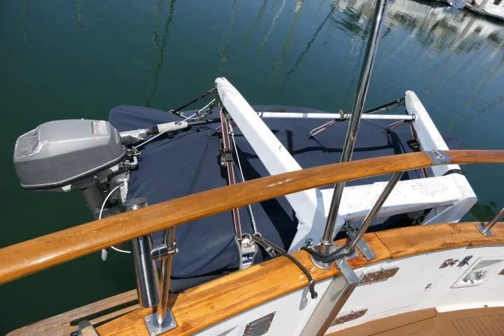 Slide: The Image of 1983 CHB 45 boat with outboard motor and wooden railing, docked in calm waters. - 46