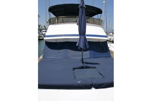 Slide: The Image of 1983 CHB 45 yacht with blue sunshade and deck cover in marina. - 48