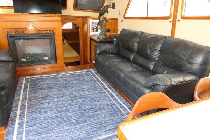 Slide: The Image of Luxurious interior of 1983 CHB 45 yacht with leather sofas and fireplace. - 5