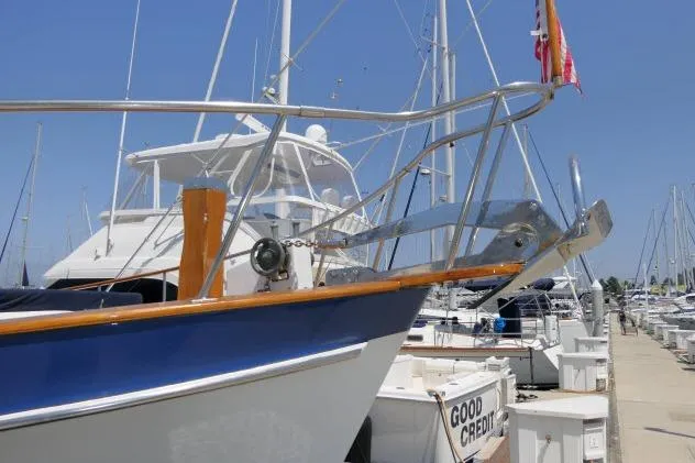 Slide: The Image of 1983 CHB 45 yacht docked at marina, blue hull, clear sky background. - 50
