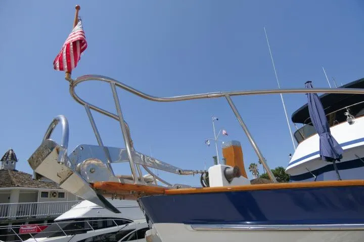 Slide: The Image of 1983 CHB 45 yacht bow with American flag, docked under clear blue sky. - 51