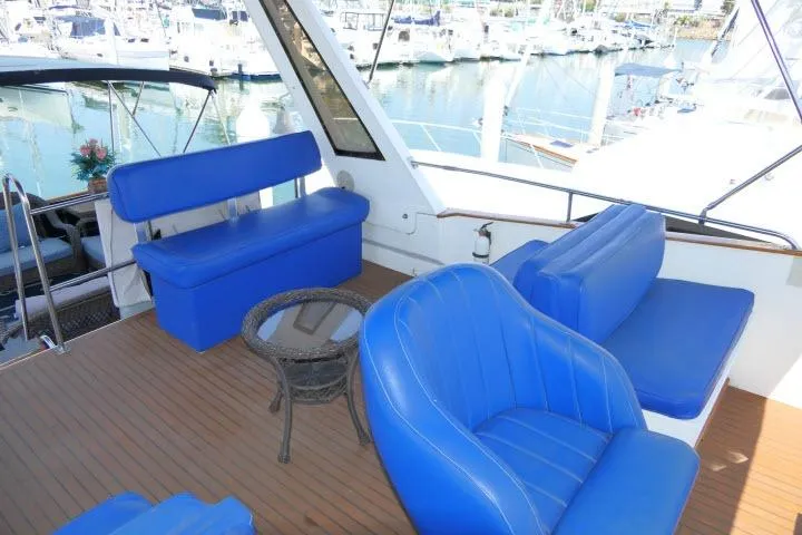 Slide: The Image of 1983 CHB 45 yacht interior with blue seating and a small glass table. - 61