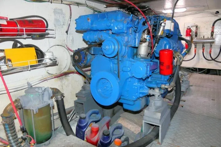 Slide: The Image of Engine room of 1983 CHB 45 boat with blue engine and maintenance supplies. - 63