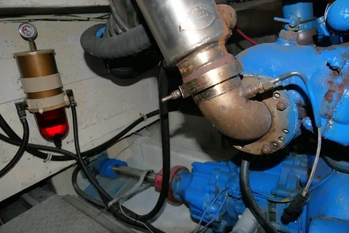Slide: The Image of Engine room of 1983 CHB 45 boat, featuring blue machinery and fuel filter system. - 69