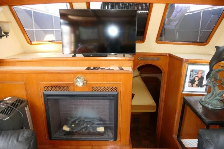 Slide: The Image of Interior of 1983 CHB 45 boat with TV, fireplace, and cozy seating area. - 7