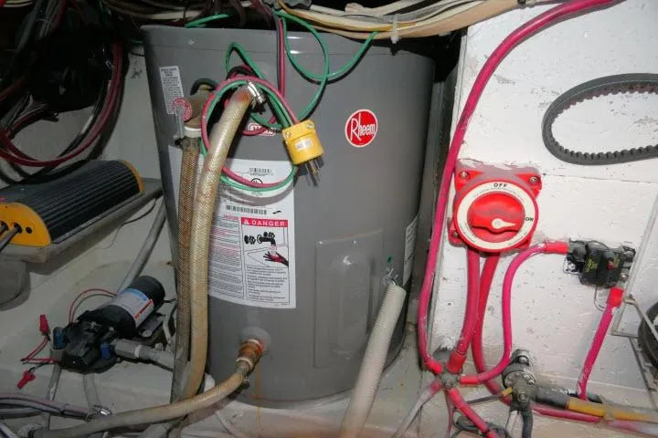 Slide: The Image of Rheem water heater in CHB 45 boat engine room, 1983 model, with wiring and plumbing connections. - 71
