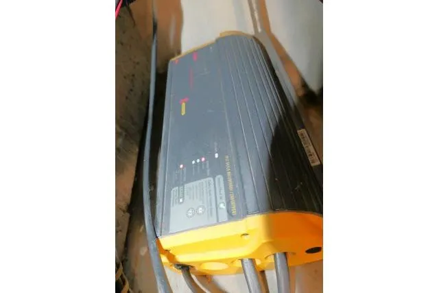 Slide: The Image of Battery charger with cables, CHB 45 model, 1983, in a dimly lit setting. - 77