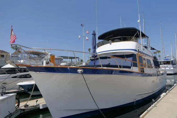 Slide: The Image of 1983 CHB 45 yacht docked at marina, featuring classic design and American flag. - 78