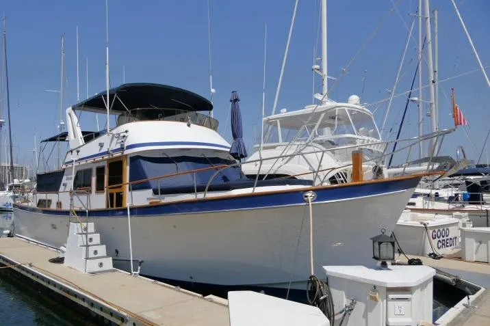 Slide: The Image of 1983 CHB 45 yacht docked at marina, featuring classic design and spacious deck. - 79