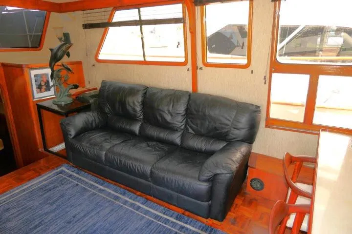 Slide: The Image of Interior of 1983 CHB 45 yacht with black leather sofa and nautical decor. - 8