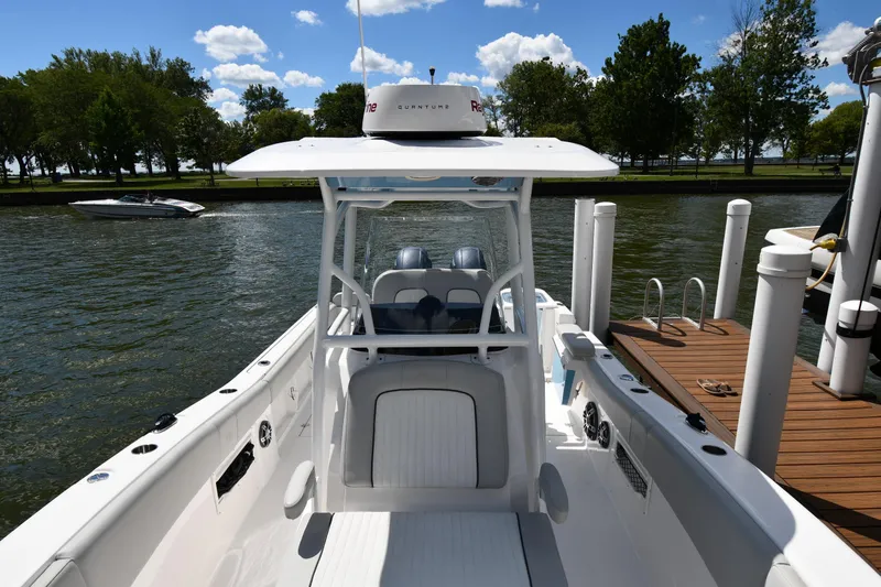 Slide: The Image of 2022 Sea Fox 268 Commander boat docked on a sunny day with trees in the background. - 10