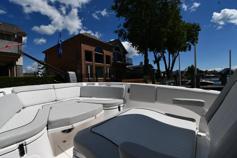 Slide: The Image of 2022 Sea Fox 268 Commander boat interior with white seating, docked near waterfront homes. - 31