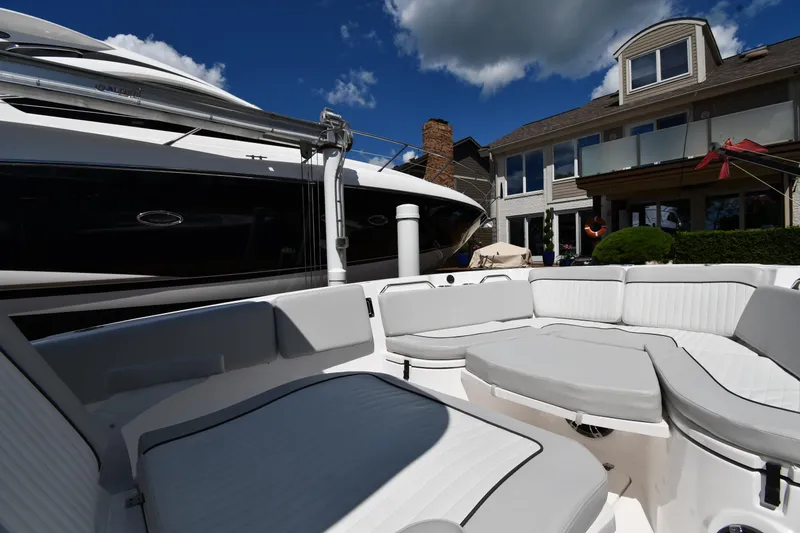 Slide: The Image of 2022 Sea Fox 268 Commander boat interior with white seating, docked near a modern house. - 32