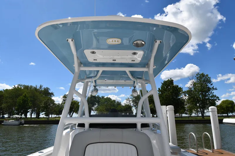 Slide: The Image of 2022 Sea Fox 268 Commander boat with blue T-top, docked by a scenic lake. - 35