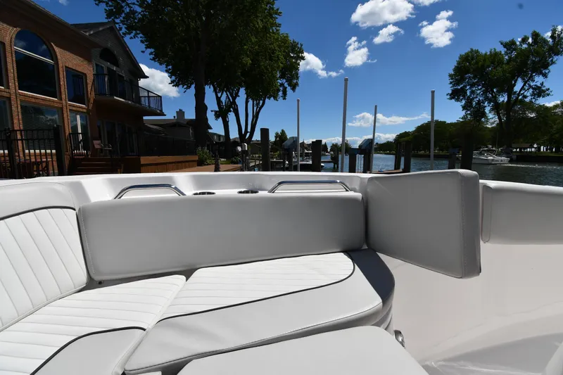 Slide: The Image of 2022 Sea Fox 268 Commander boat interior with white seating, docked near waterfront homes. - 37