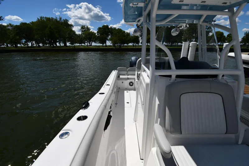 Slide: The Image of 2022 Sea Fox 268 Commander boat on water, sunny day, trees in background. - 41