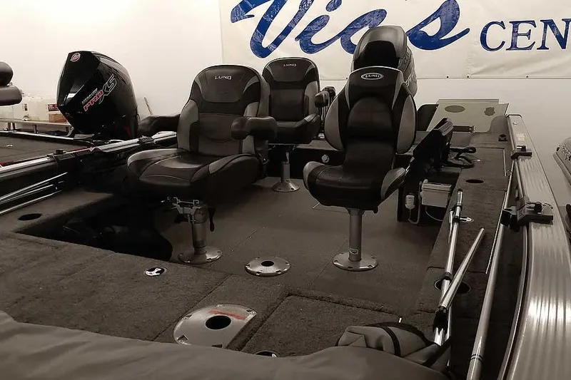 Slide: The Image of 2016 Lund 2075 Pro Guide boat interior with seating and motor, displayed indoors. - 10