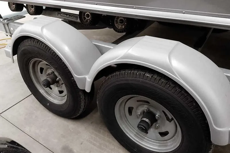 Slide: The Image of Dual axle trailer for 2016 Lund 2075 Pro Guide boat, featuring sturdy wheels and fenders. - 12