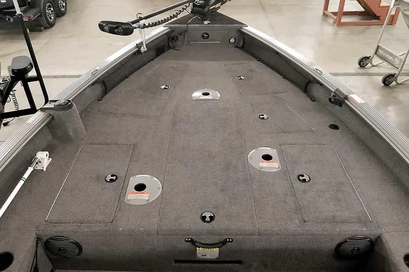 Slide: The Image of 2016 Lund 2075 Pro Guide boat interior with carpeted deck and storage compartments. - 19