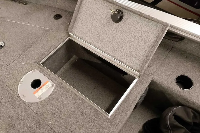 Slide: The Image of 2016 Lund 2075 Pro Guide boat storage compartment with open hatch and carpeted interior. - 22