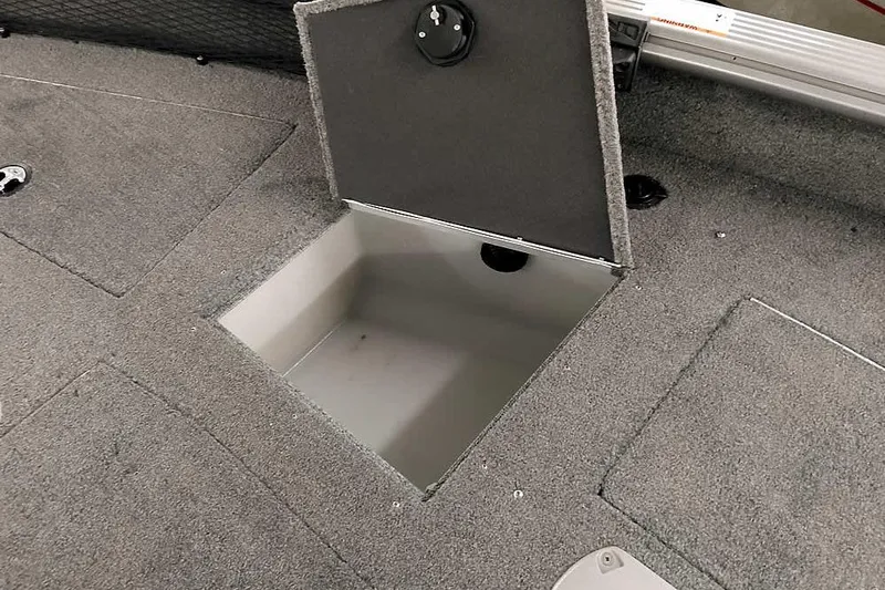 Slide: The Image of 2016 Lund 2075 Pro Guide boat storage compartment with open hatch, gray carpeted interior. - 23