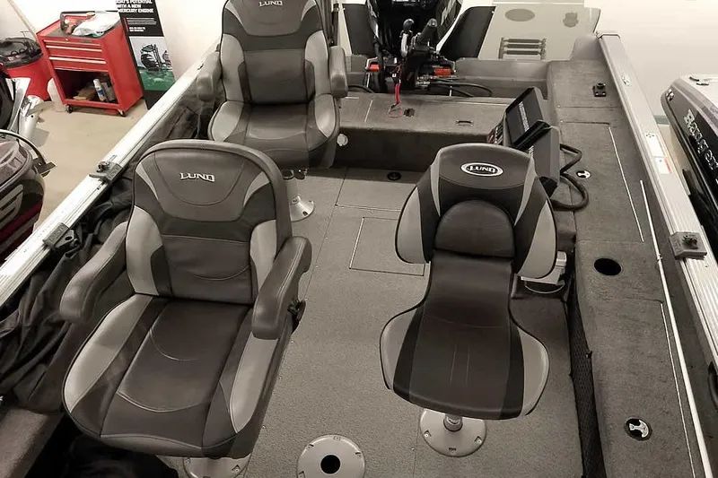 Slide: The Image of 2016 Lund 2075 Pro Guide boat interior with three cushioned seats and fishing equipment. - 28