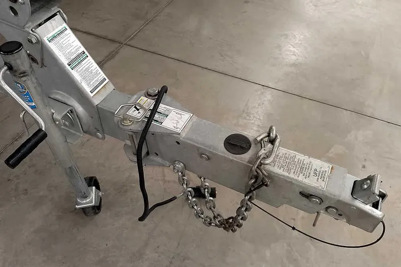 Slide: The Image of Trailer hitch of a 2016 Lund 2075 Pro Guide boat, featuring safety chains and labels. - 42