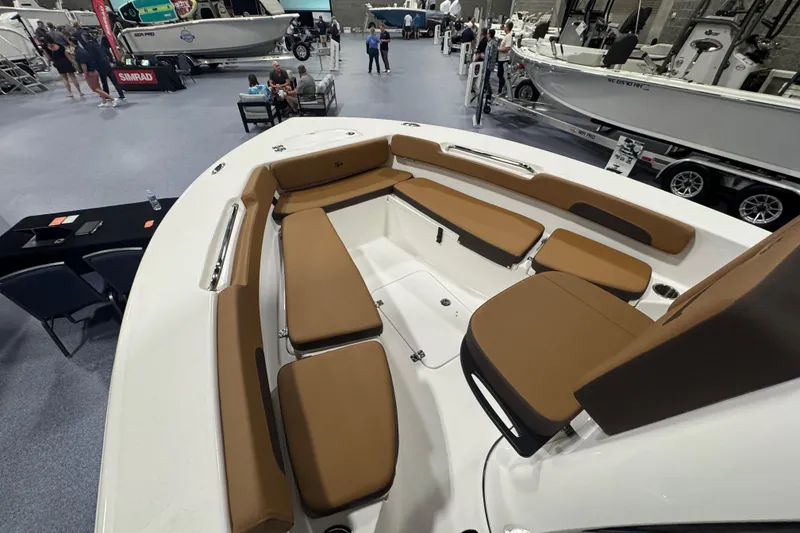 Slide: The Image of 2026 Sea Pro 202 Center Console boat interior with brown seating at a boat show. - 15