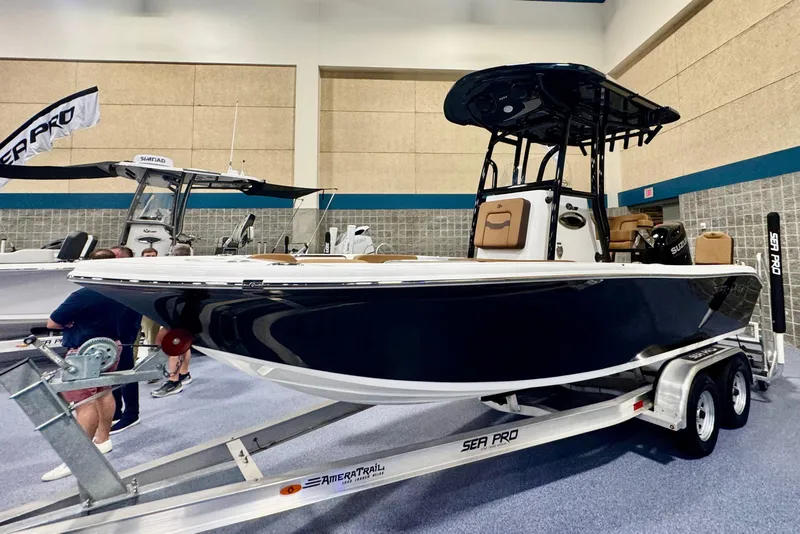 Slide: The Image of 2026 Sea Pro 202 Center Console boat on trailer at indoor exhibition. - 2