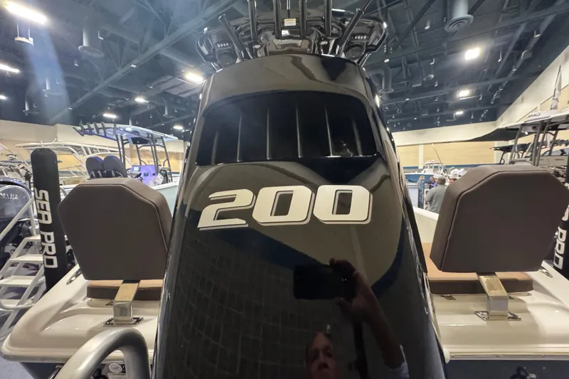 Slide: The Image of 2026 Sea Pro 202 Center Console boat with 200 horsepower engine displayed indoors. - 6