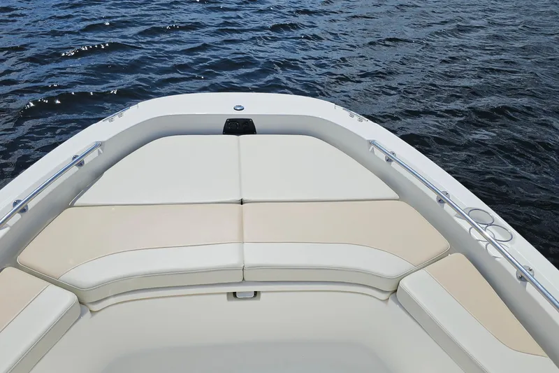 Slide: The Image of 2018 Boston Whaler 210 Dauntless boat bow with cushioned seating on water. - 13