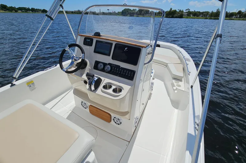 Slide: The Image of 2018 Boston Whaler 210 Dauntless boat interior with steering console on calm water. - 16