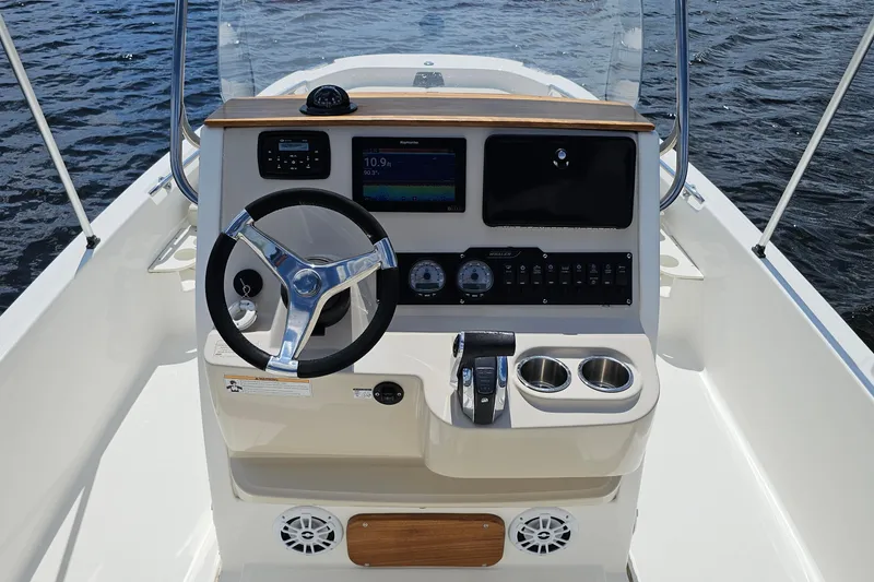 Slide: The Image of 2018 Boston Whaler 210 Dauntless boat console with steering wheel and navigation controls. - 17