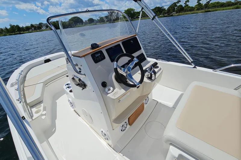 Slide: The Image of 2018 Boston Whaler 210 Dauntless boat interior with steering console on a sunny day. - 18