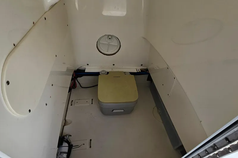 Slide: The Image of Interior of 2018 Boston Whaler 210 Dauntless boat with storage compartment and portable toilet. - 22