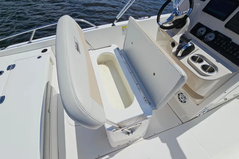 Slide: The Image of 2018 Boston Whaler 210 Dauntless boat interior with open storage compartment and steering console. - 25