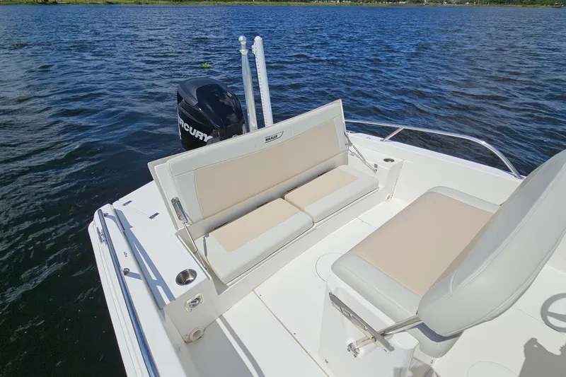 Slide: The Image of 2018 Boston Whaler 210 Dauntless boat interior with seating and Mercury engine on water. - 30