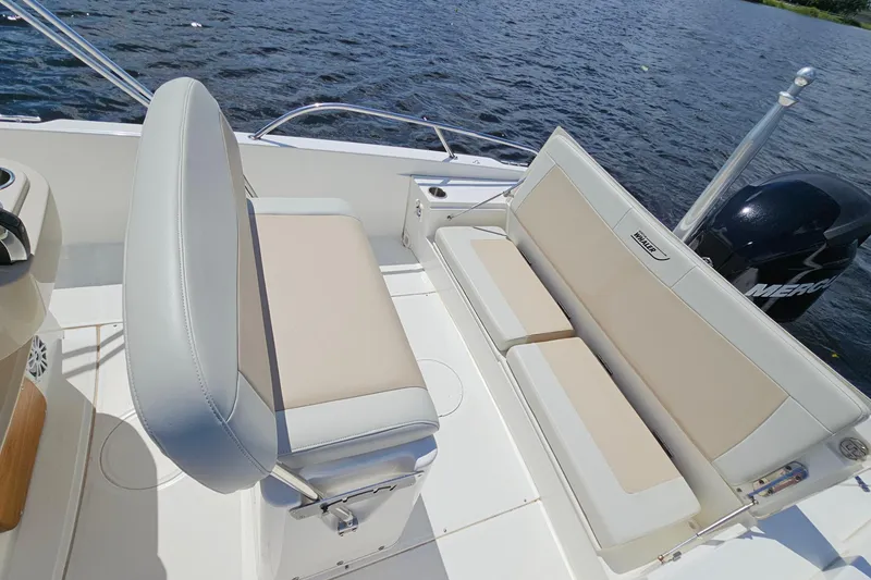 Slide: The Image of 2018 Boston Whaler 210 Dauntless boat interior with seating and Mercury engine on water. - 31