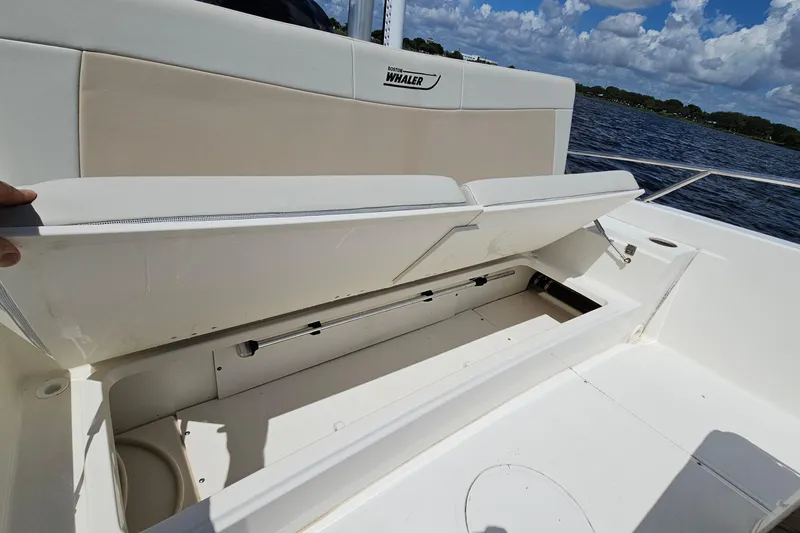 Slide: The Image of 2018 Boston Whaler 210 Dauntless boat with open storage compartment, on a sunny day. - 32