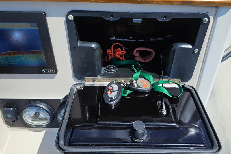 Slide: The Image of Dashboard of 2018 Boston Whaler 210 Dauntless with controls and storage compartment. - 37