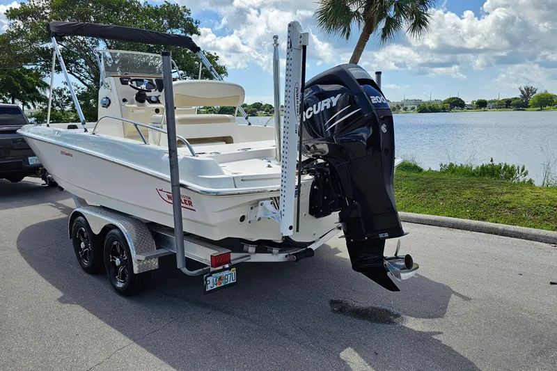 Slide: The Image of 2018 Boston Whaler 210 Dauntless boat on trailer, parked near a lake. - 4