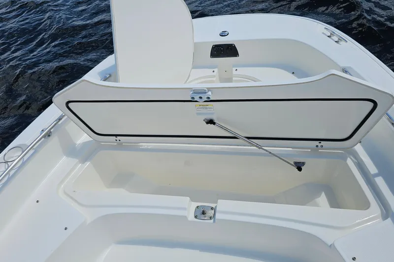 Slide: The Image of 2018 Boston Whaler 210 Dauntless boat storage compartment open on water. - 42