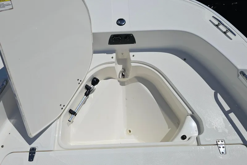 Slide: The Image of 2018 Boston Whaler 210 Dauntless boat storage compartment with open hatch and rod holder. - 44